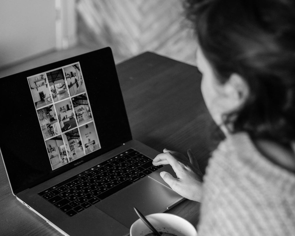 Free black and white stock photo of a woman working from a laptop computer